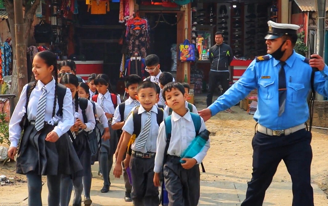पैदल यात्रुलाई बाटो काटन सहयोग गर्दै ट्राफिक प्रहरी
